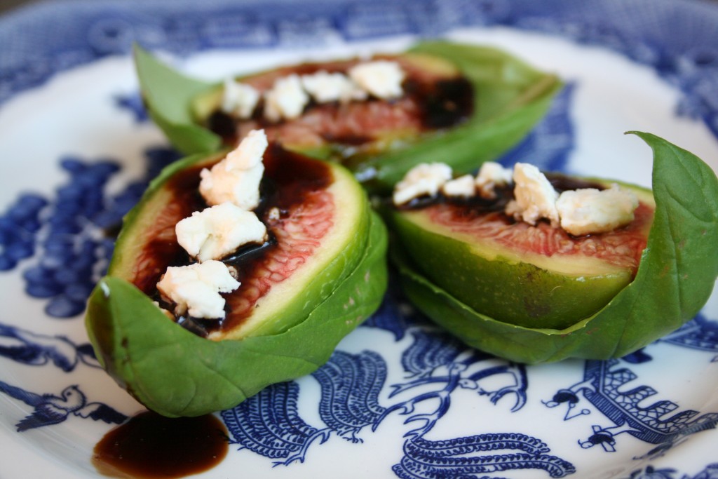 Figs with balsamic drizzle and feta on a basil leaf