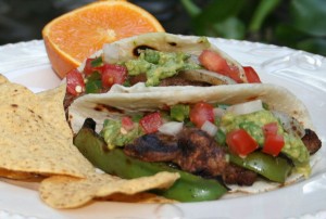 Rib Eye steak on the grill with peppers and onions
